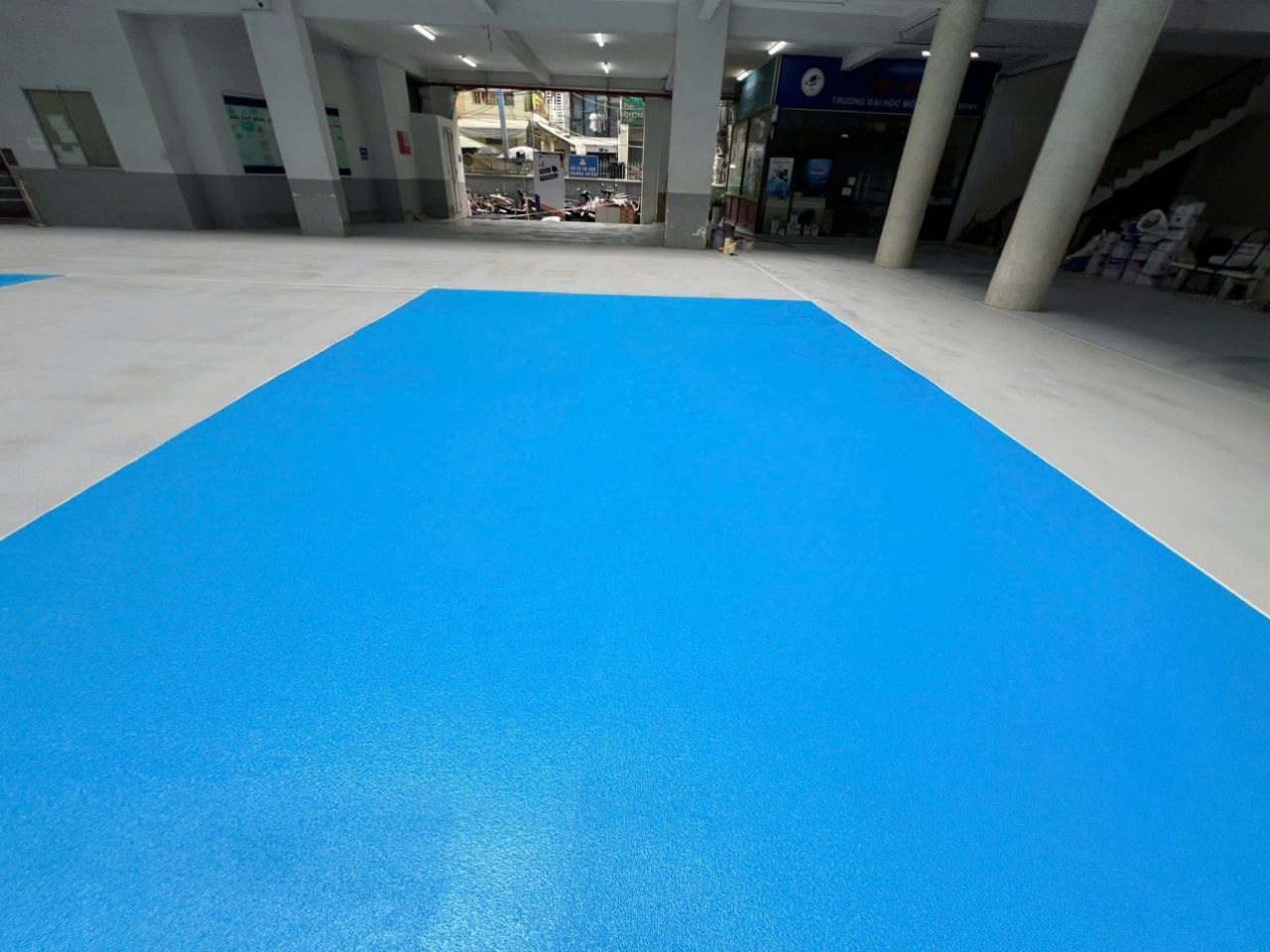 Sàn nhà xe epoxy xanh dương chống trượt hoàn thiện bằng kỹ thuật rắc cát thạch anh broadcast