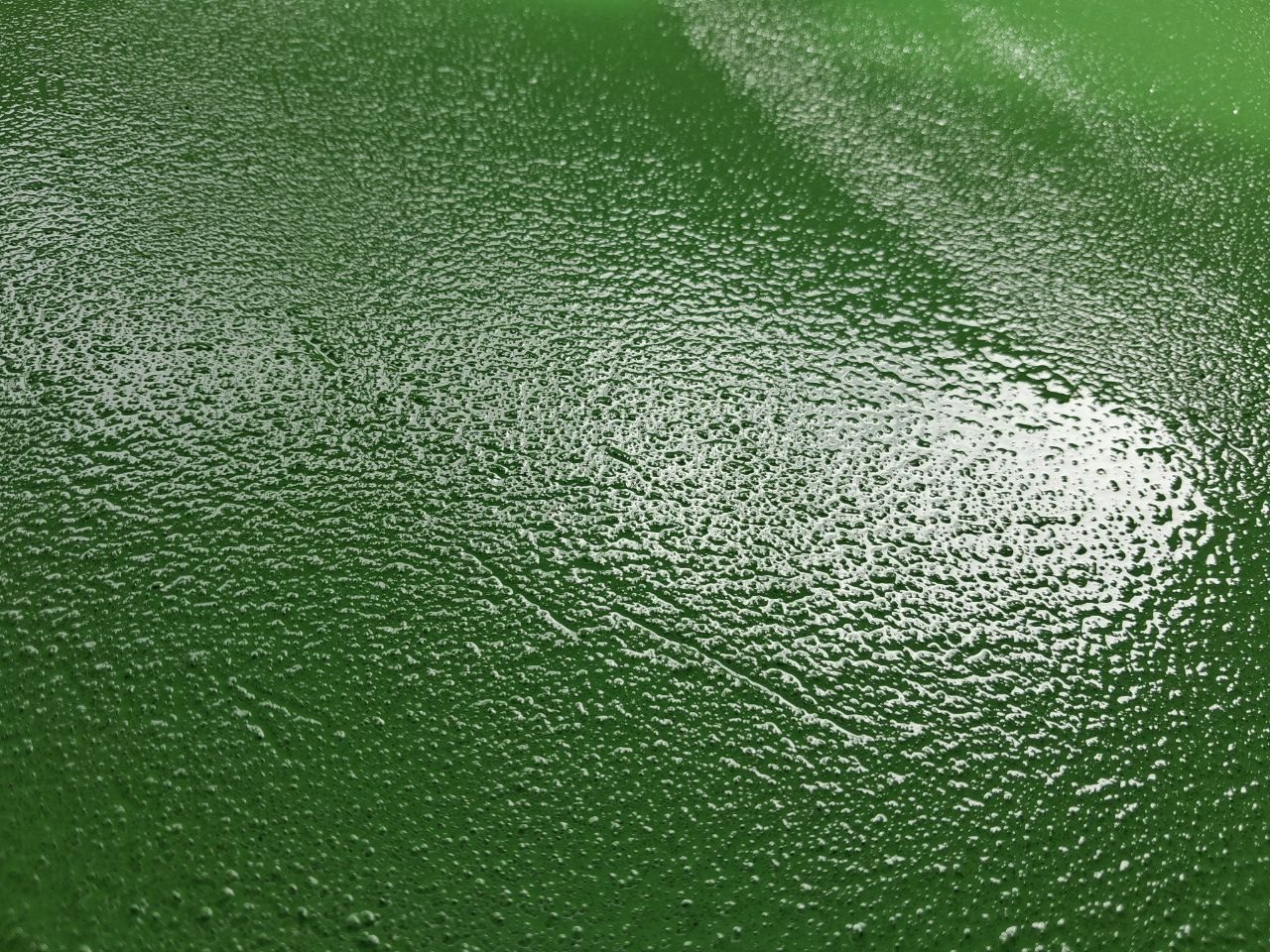 Cận cảnh bề mặt sơn epoxy xanh lá rắc cát thạch anh tạo nhám chống trượt trước khi phủ lớp hoàn thiện