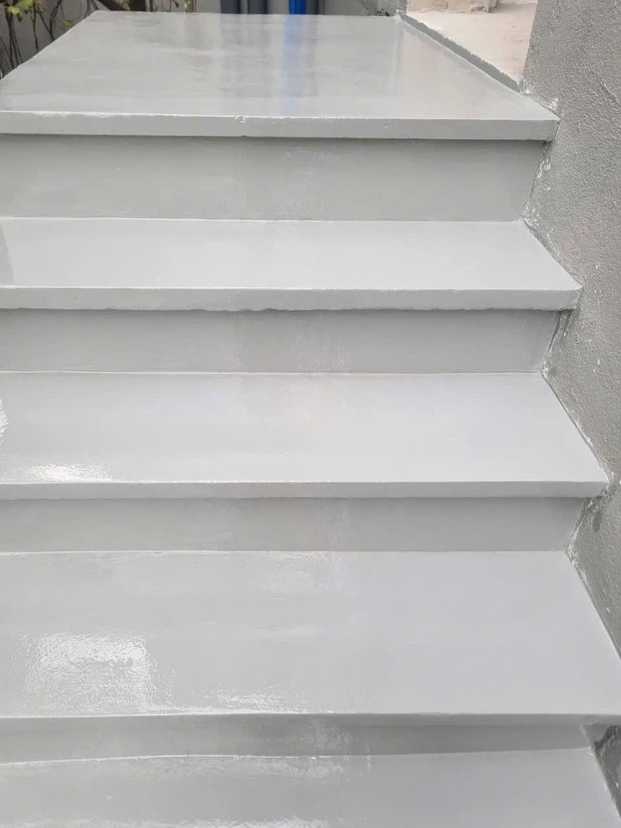 Cận cảnh cầu thang sơn epoxy màu trắng xám – bề mặt hạt cát thạch anh nhám đồng đều, mép sắc nét