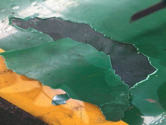 Sàn epoxy bong tróc từng mảng lớn do nền bê tông nhiễm dầu mỡ