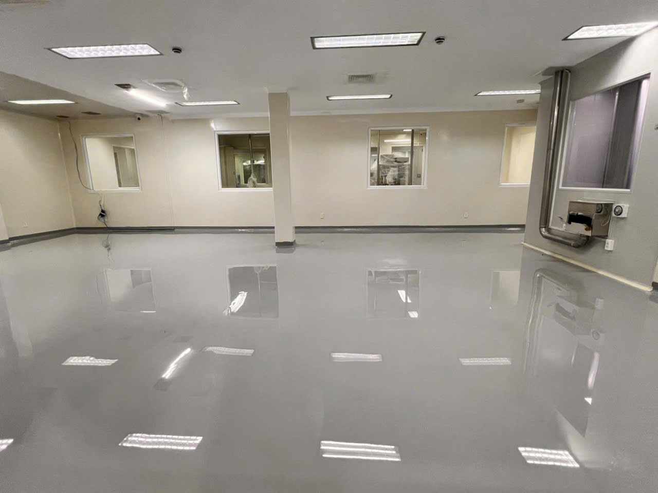 Phòng sản xuất với sàn tự phẳng và dải bo chân tường liên tục quanh chu vi phòng và chân cột