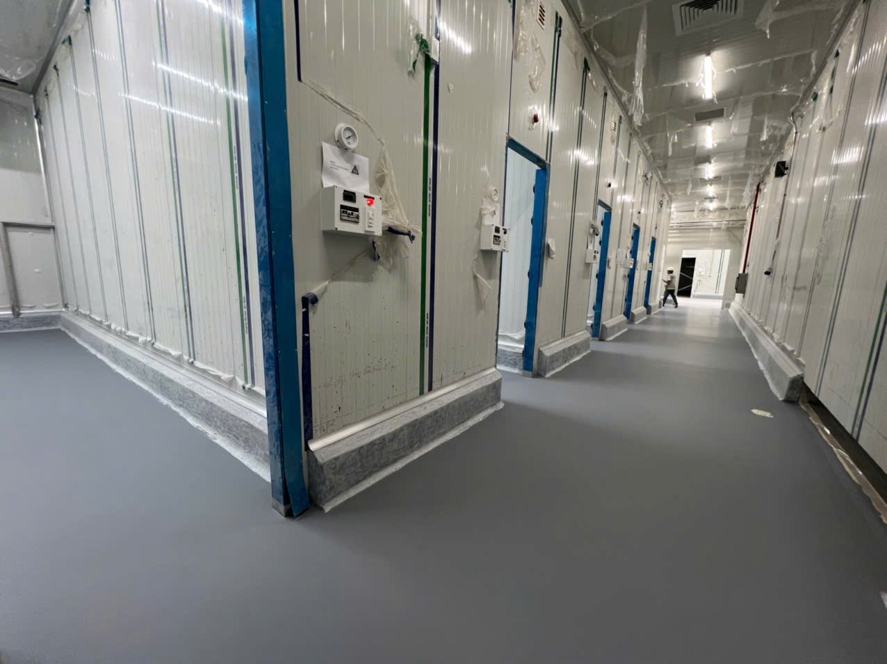 Hành lang kho lạnh hoàn thiện sàn vữa PU màu xám, có chân khay bo cong dọc chân panel