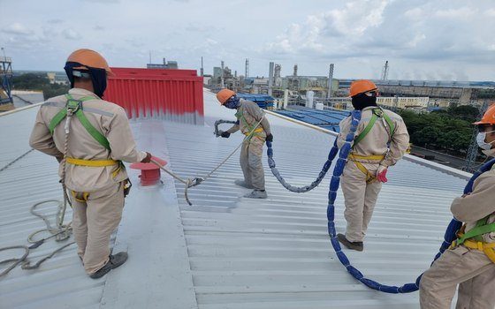 Đội thi công đang phun polyurea trực tiếp trên mái tôn nhà máy công nghiệp cao tầng